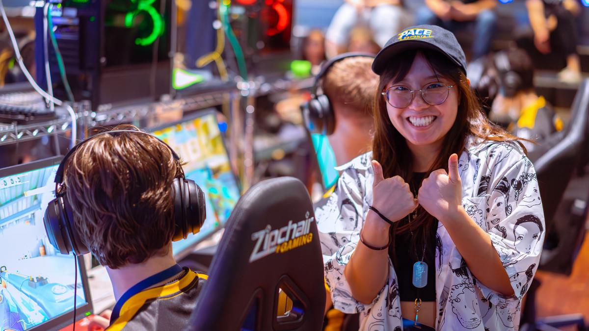  student, Julia Cardillo gives the thumbs up next to a  Esports athlete 
